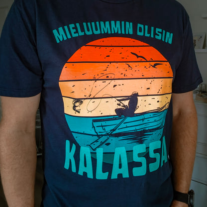 Tummansininen Mieluummin olisin kalassa -t-paita kalastaja- ja veneprintillä, henkilön päällä edestä kuvattuna.