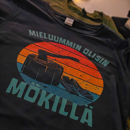 Tumma Mieluummin olisin mökillä -t-paita, jonka printissä on kirves ja klapeja, kuvattuna tasolla.
